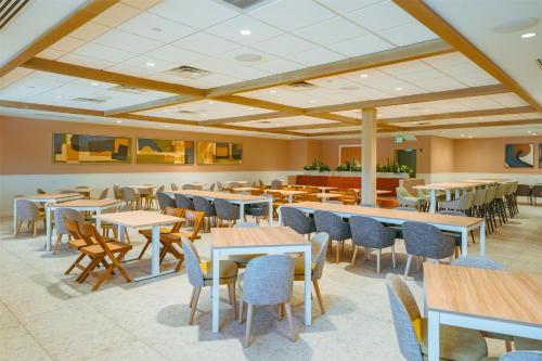 a dining room with tables and chairs and tablesktop at Embassy Suites By Hilton Orlando Sunset Walk in Kissimmee