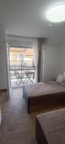 a bedroom with two beds and a balcony with a table at Petrovaradinski Dvor in Petrovaradin