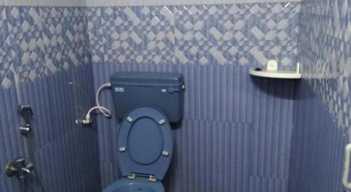 a bathroom with a blue toilet in a stall at Nelligudda Homestay in Kalasa