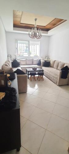 a living room with a couch and a table at Appartement avec Piscine à Tamaris, Confort, Vue Jardin et Plages à Proximité in Tamaris