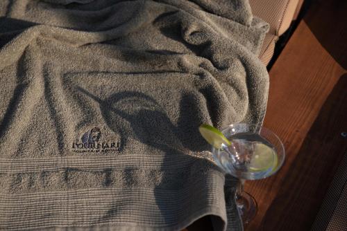 a glass with a lime on top of a blanket at Pournari Mountain Rooms in Toroni