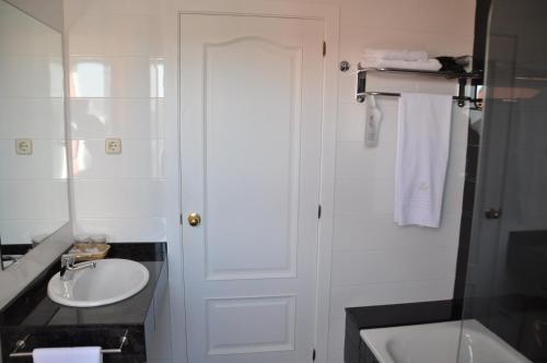 a white bathroom with a sink and a shower at Hotel Crunia I A Coruña in A Coruña