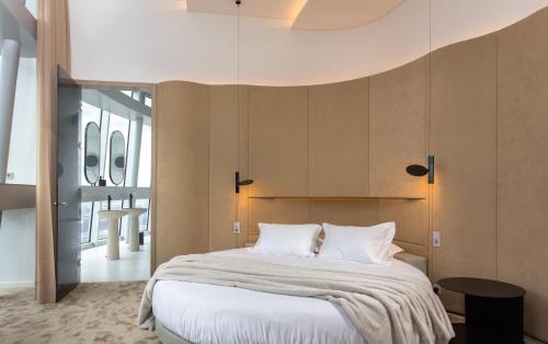 a bedroom with a large bed with white sheets at Vilnius TV Tower Apartments DEBESYS in Vilnius
