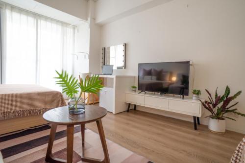 a living room with a large flat screen tv at 樂居 台北 in T'ung-ko