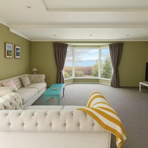 a living room with a white couch and a large window at Lakeside Retreat with Swim Spa in Hamilton