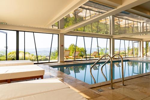 a house with a swimming pool and windows at Mas des Herbes Blanches Hôtel & Spa – Relais & Châteaux in Joucas