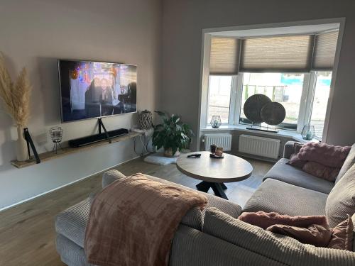 a living room with a couch and a table at Paleisje aan zee in IJmuiden