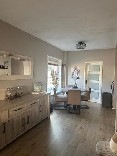 a living room with a table and a dining room at Paleisje aan zee in IJmuiden