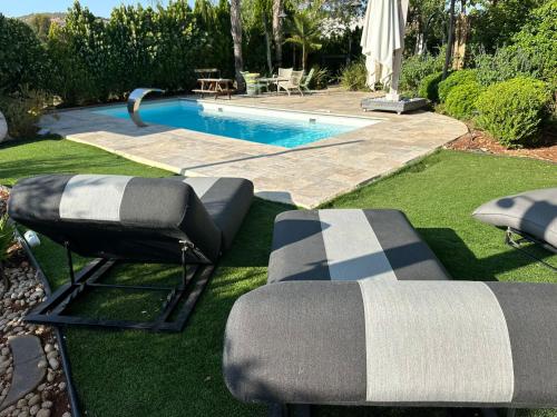 a yard with a pool with two chairs and a swimming pool at איול Ayul in Sede Eli‘ezer