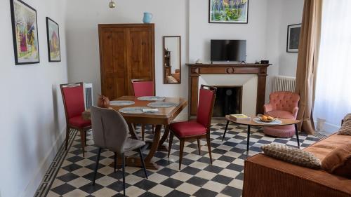 a living room with a table and chairs and a fireplace at Les chambres de l'ATELIER à Montignac Lascaux in Montignac