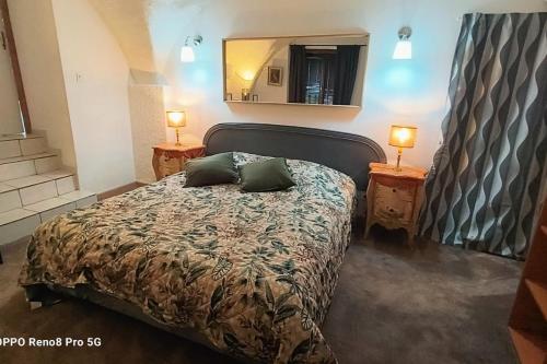 a bedroom with a bed with two lamps and a mirror at La chacuniere in Saint-Amant-Tallende