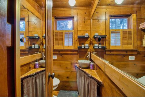 a wooden bathroom with two sinks and a toilet at Ray's Dear Cottage- A relaxing place in the woods in Wrightwood