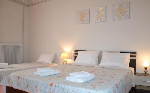 a bedroom with two beds with towels on them at Daizy's Apartment in Volos