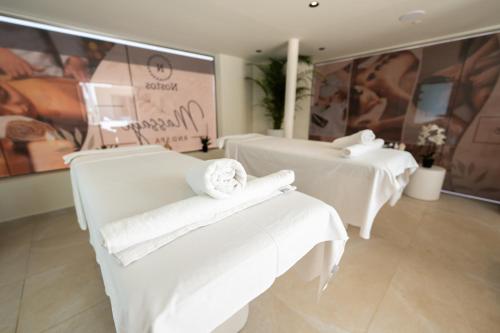 a room with two beds with white towels at Nostos Beach Boutique Hotel in Balíon