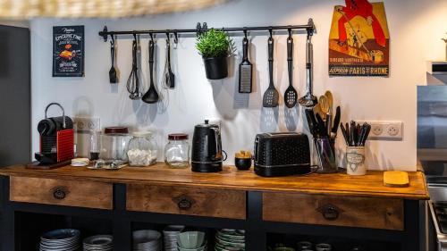 a kitchen counter with utensils hanging on a wall at L'Ombelle in Selongey