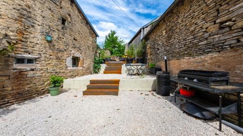 a brick building with stairs and a grill in front of it at L'Ombelle in Selongey