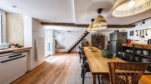 a kitchen and dining room with a wooden table and chairs at L'Ombelle in Selongey