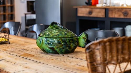 a green glass container sitting on a wooden table at L'Ombelle in Selongey