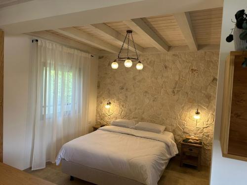 a bedroom with a bed and a stone wall at איול Ayul in Sede Eli‘ezer