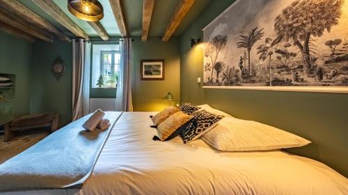 a bedroom with a large bed with pillows on it at L'Ombelle in Selongey