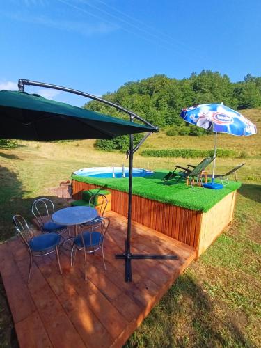 a patio with a table and chairs and an umbrella at Apartman Denis Una in Lužine