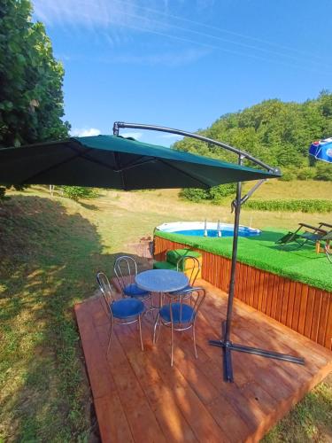 a patio with a table and chairs and a pool at Apartman Denis Una in Lužine