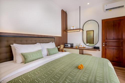 a bedroom with a large bed and a mirror at Ellavie Villa Nusa Dua in Nusa Dua
