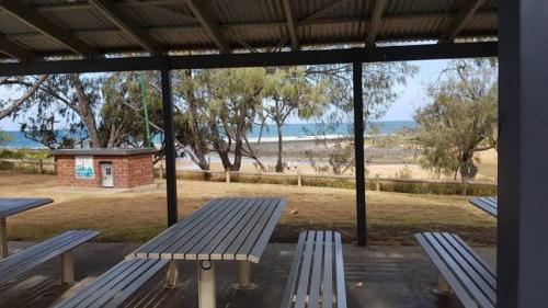 two benches in a pavilion with a view of the beach at Lakeside Retreat with Swim Spa in Hamilton