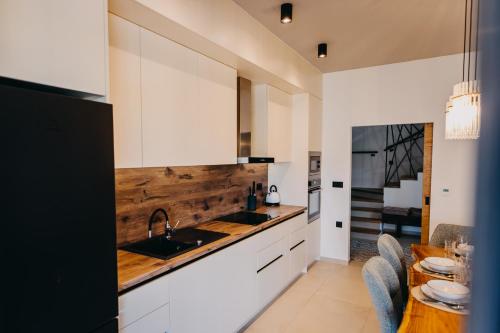 a kitchen with white cabinets and a wooden counter top at Novak Home in Štrigova
