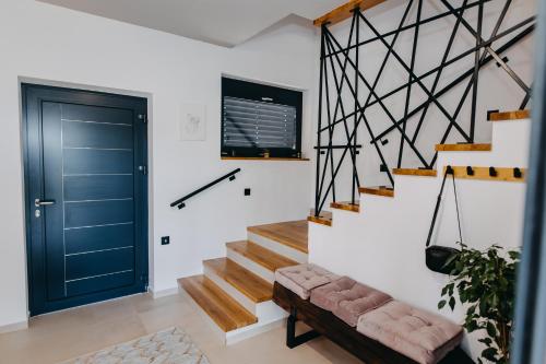 a hallway with a blue door and a staircase at Novak Home in Štrigova