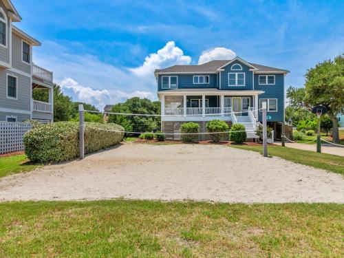 a blue house with a volleyball court in front of a house at 2072 - Laughing Duck in Duck