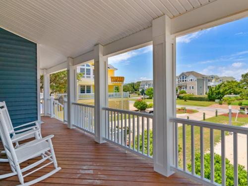a porch with a rocking chair and a view of the street at 2072 - Laughing Duck in Duck
