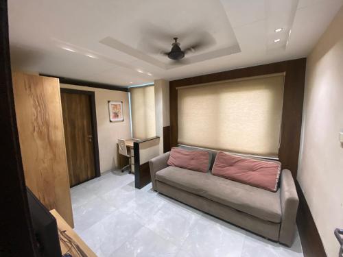 a living room with a couch and a desk at Hotel Village Villa in Indore
