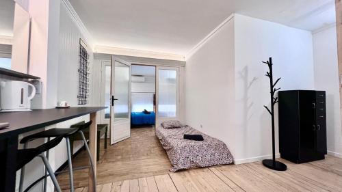 a kitchen with white walls and a table and a couch at Coliving Ajaccio in Ajaccio