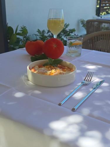 a bowl of food on a table with a glass of wine at Ammoudeli Apartments in Plomarion