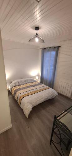 a bedroom with a bed in a room with a window at Maison au calme avec terrasse, climatisé in Vertaizon