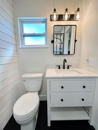 a white bathroom with a toilet and a sink at Pink Maraboi Resort in Kisumu