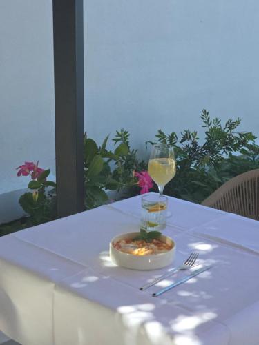 a table with a bowl of food and a glass of wine at Viento Luxury Apartments in Plomarion
