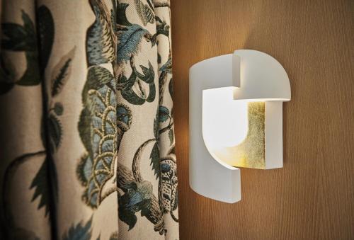 a white lightswitch on a wooden door with curtains at Hôtel Prince de Conti - Hôtel Rénové in Paris