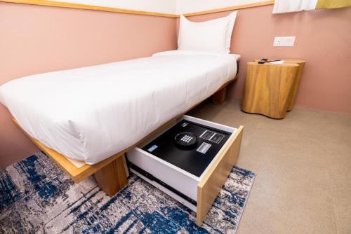 a room with two beds and a table in it at mu petite in Ipoh