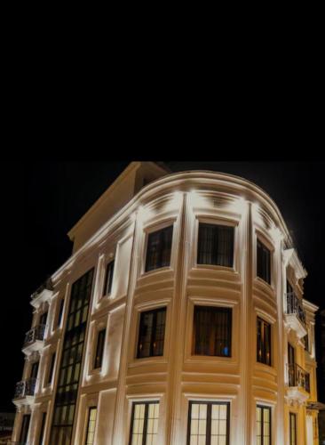 a large white building with windows at night at Hotel Zava Civic Center in Bucharest