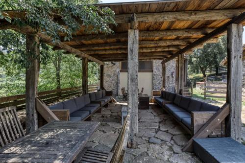 a pergola with couches and tables in a yard at Can Pei in Oix
