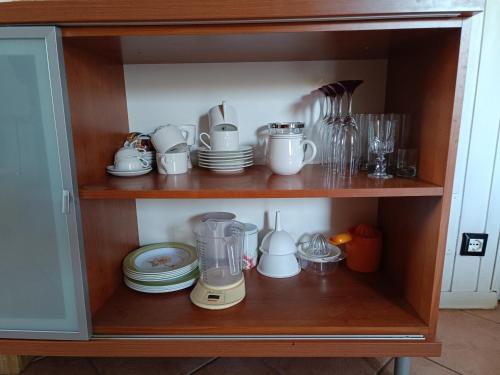 a cupboard with a bunch of dishes and a blender at Mansarda Eiretta in Ceres