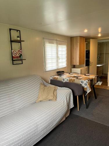 Un dormitorio con dos camas y una mesa dentro. en Ossau Du Lit, en Gère-Belesten
