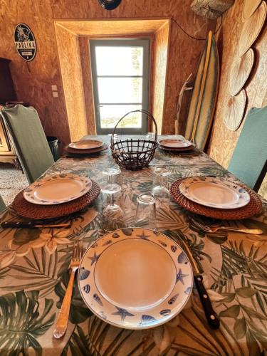 - une table avec des assiettes et des ustensiles dans l'établissement U Magazinu, à Pino