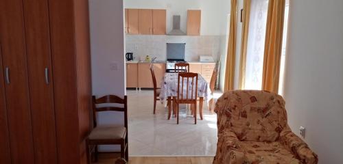 Una cocina y un comedor con mesa y sillas. en Apartmani Maric, en Tivat