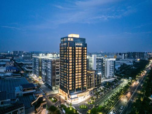 a tall building in a city at night at Bodun International Apartment Foshan Shunde Fengjian Water Village Branch in Shunde
