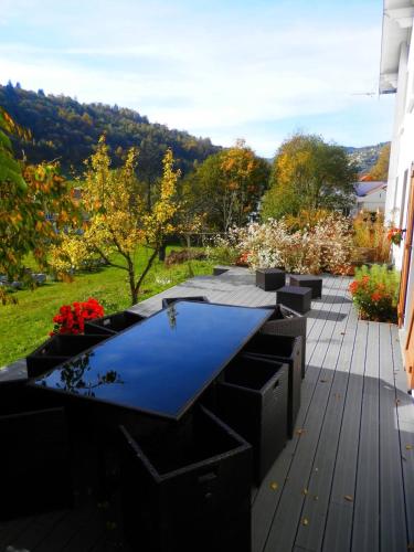 a patio with a blue table on a deck at Le Gîte d'Orion in La Bresse