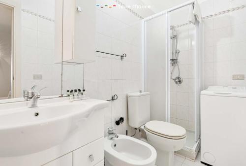 a white bathroom with a toilet and a sink at Mangia, Prega, Ama TerreMarine in Riomaggiore