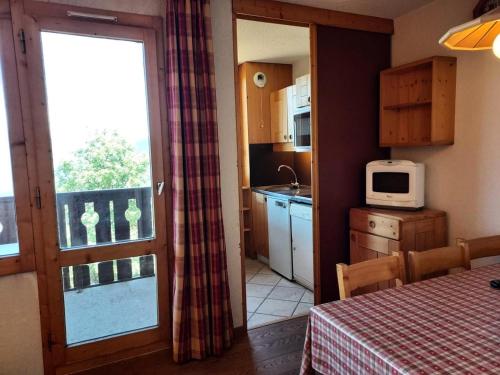 une petite cuisine avec une table et un micro-ondes dans l'établissement Résidence Cote Soleil G - COTE SOLEIL 31 MAE-5921, à Valmorel
